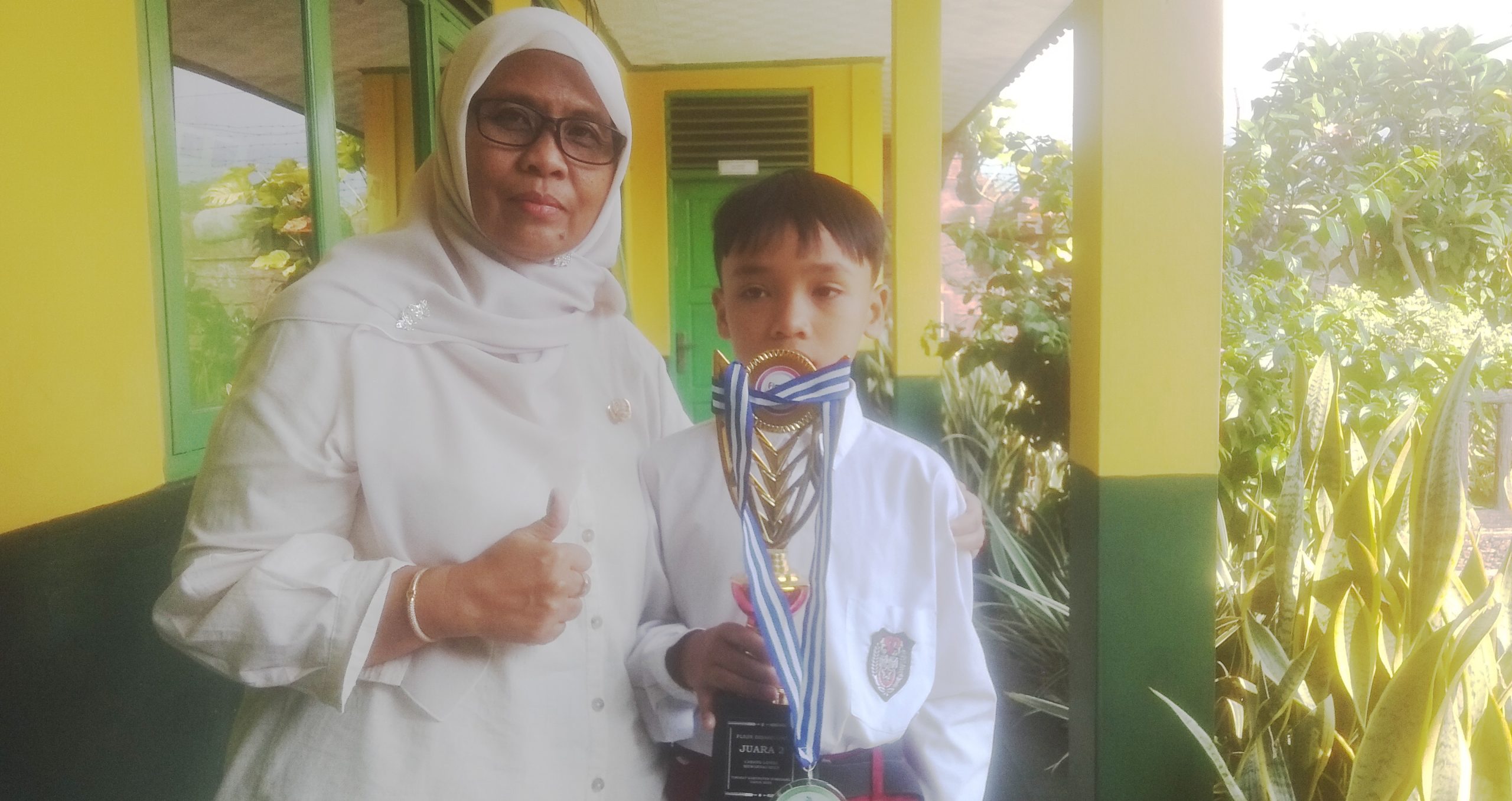 Cucu Rohaeti, Kepala SLB Mi'roojutaqwa  bersama siswanya yang meraih juara ( Dok di Hariansumedang.com / Tatang Tarmedi )