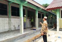 Kepala SDN Cimuncang, Udis Supriadi S.Pdi sedang memonitor pekerja bangunan ( Dok. Harian Sumedang / Supriadi )