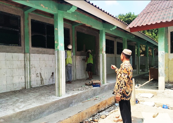 Kepala SDN Cimuncang, Udis Supriadi S.Pdi sedang memonitor pekerja bangunan ( Dok. Harian Sumedang / Supriadi )