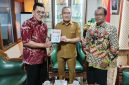 Penyerahan buku Memburu Pembunuh Wartawan Fuad Muhammad Syafruddin yang ditulis Anggota Tim Pencari Fakta PWI DIY, Asril Sutan Marajo kepada Bupati Bantul Halim Muslih. (Dok. PWI DIY)