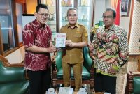Penyerahan buku Memburu Pembunuh Wartawan Fuad Muhammad Syafruddin yang ditulis Anggota Tim Pencari Fakta PWI DIY, Asril Sutan Marajo kepada Bupati Bantul Halim Muslih. (Dok. PWI DIY)