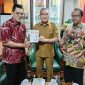 Penyerahan buku Memburu Pembunuh Wartawan Fuad Muhammad Syafruddin yang ditulis Anggota Tim Pencari Fakta PWI DIY, Asril Sutan Marajo kepada Bupati Bantul Halim Muslih. (Dok. PWI DIY)